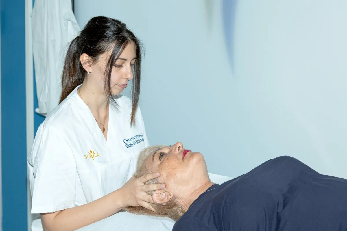 Virginia Sciarrotta durante una seduta di osteopatia, con le mani sul capo della paziente