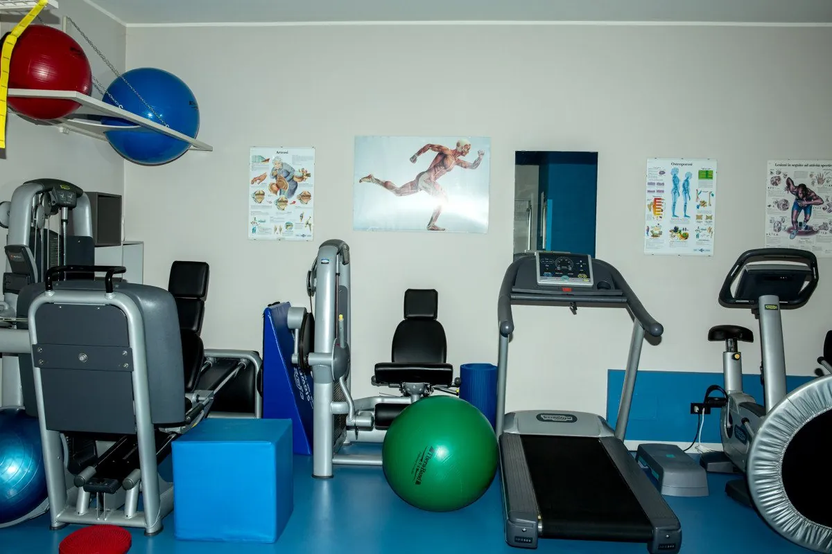 Sala di recupero motorio di MyoLab: attrezzi, palle e tapis roulant su pavimento blu